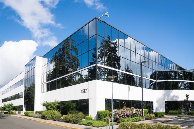 Modern glass-fronted commercial building under a blue sky